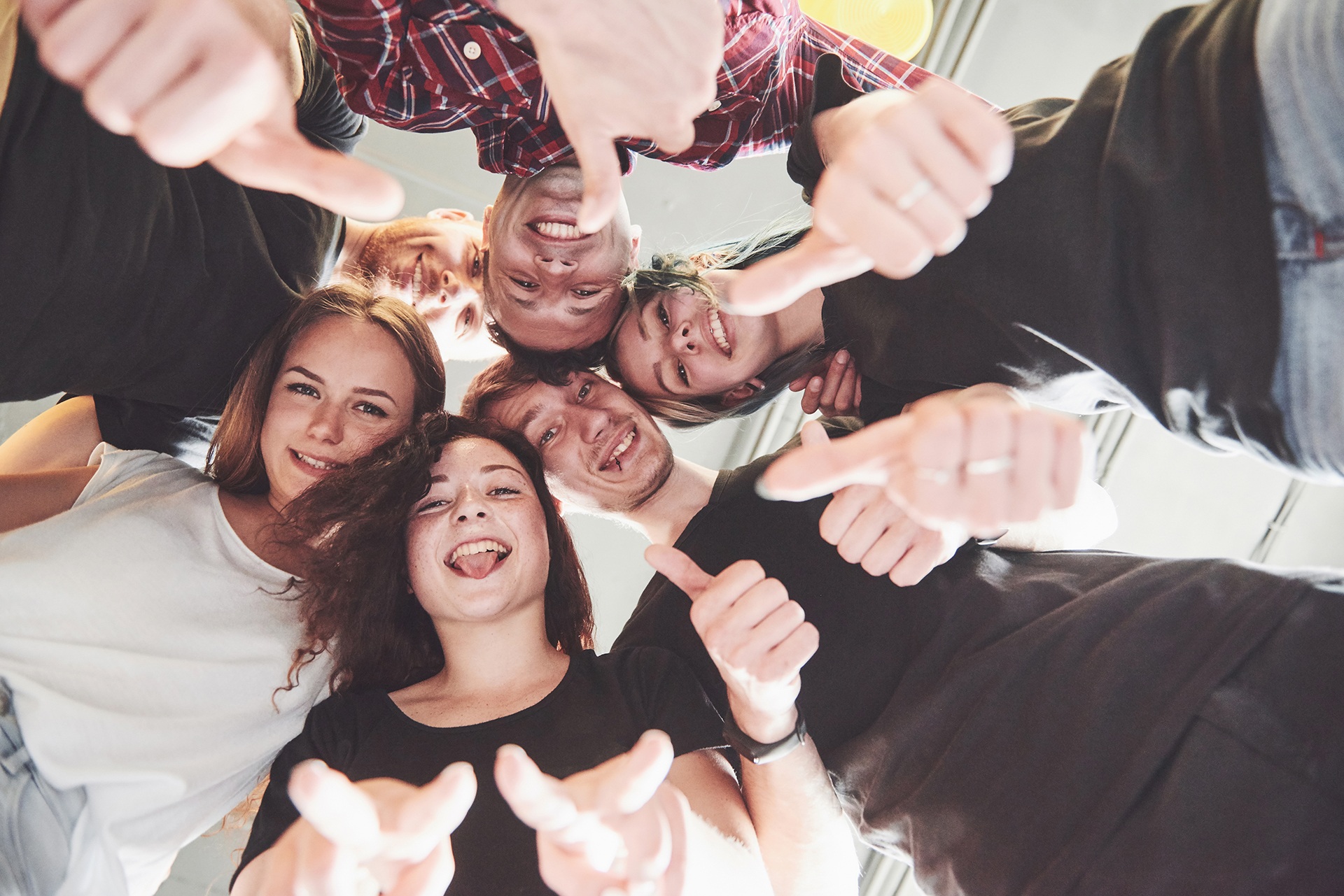 Happy group of friends with their hands together in the middle.